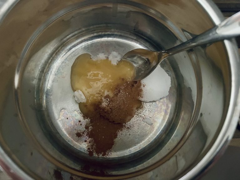 Honig und Kokosöl mit Gewürzen erwärmen
